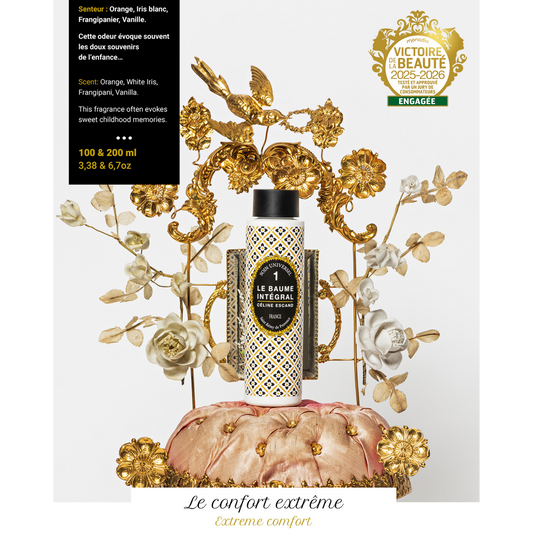 Flacon n°1 du Baume Intégral Céline Escand, soin universel bio parfumé à l’orange, iris blanc, frangipanier et vanille, présenté sur fond orné de fleurs et d’oiseaux dorés.